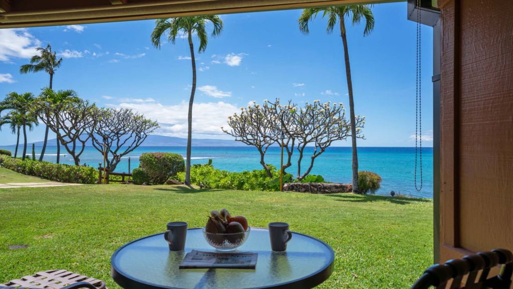Photo of ground level private patio with ocean and Lanai Island view. Room 107